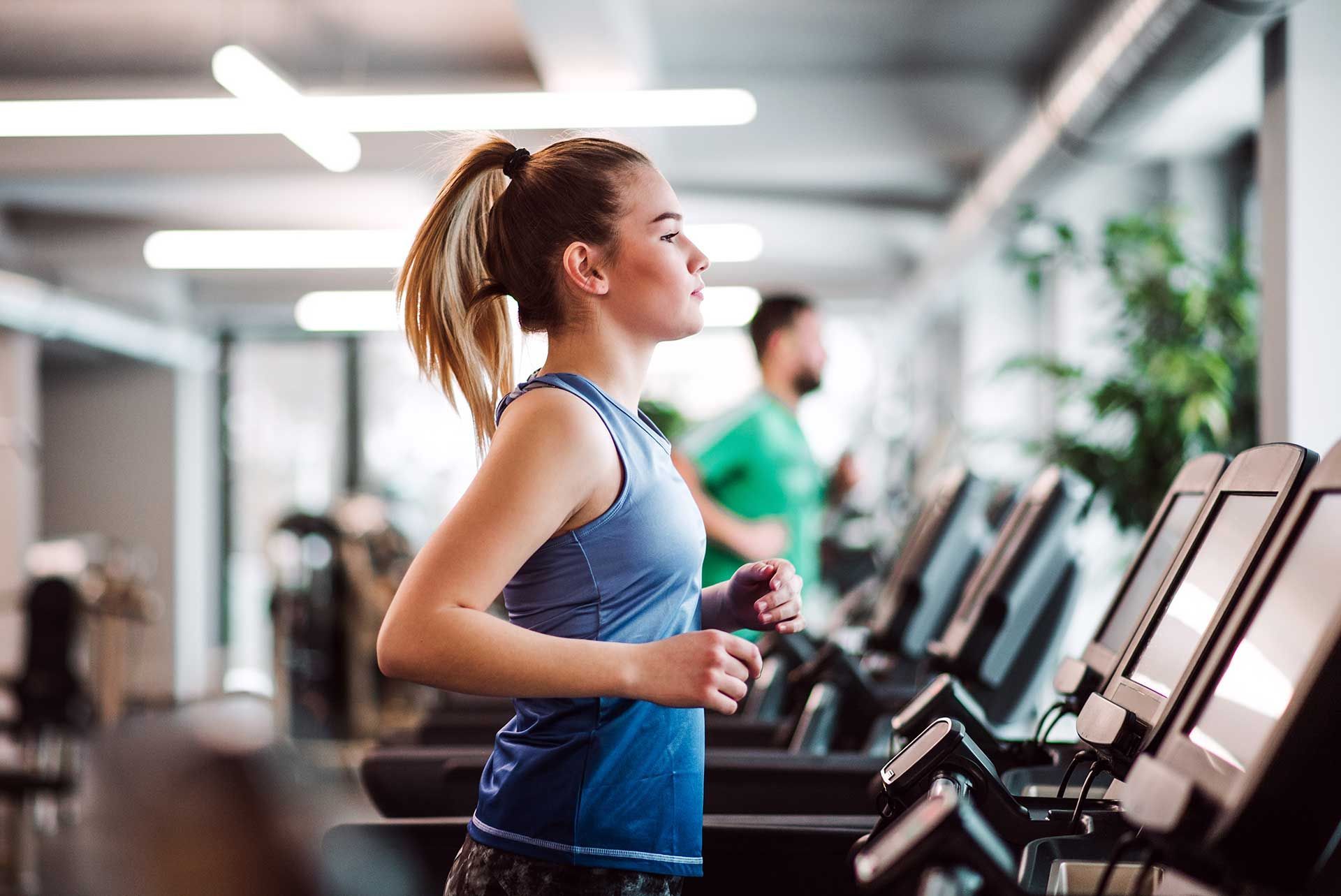 young girl or woman doing cardio workout in a gym.