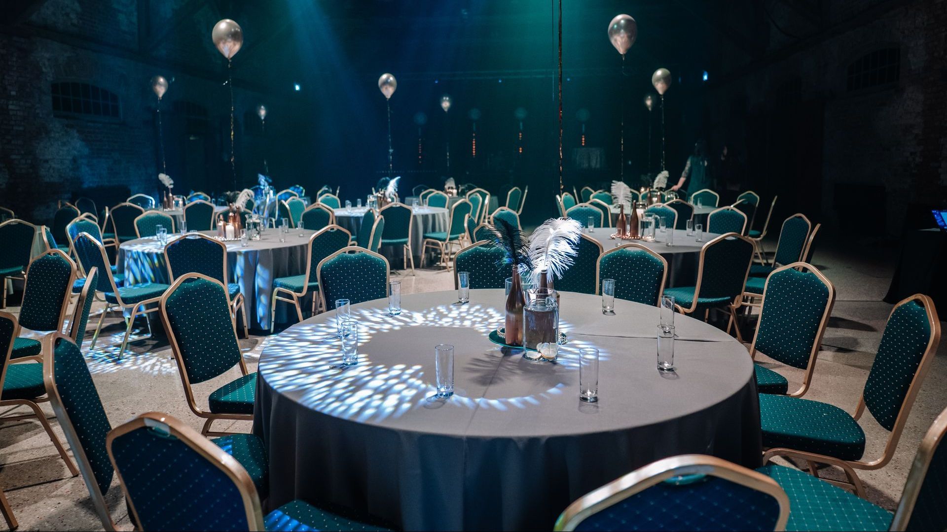 A large room with tables and chairs set up for a party.