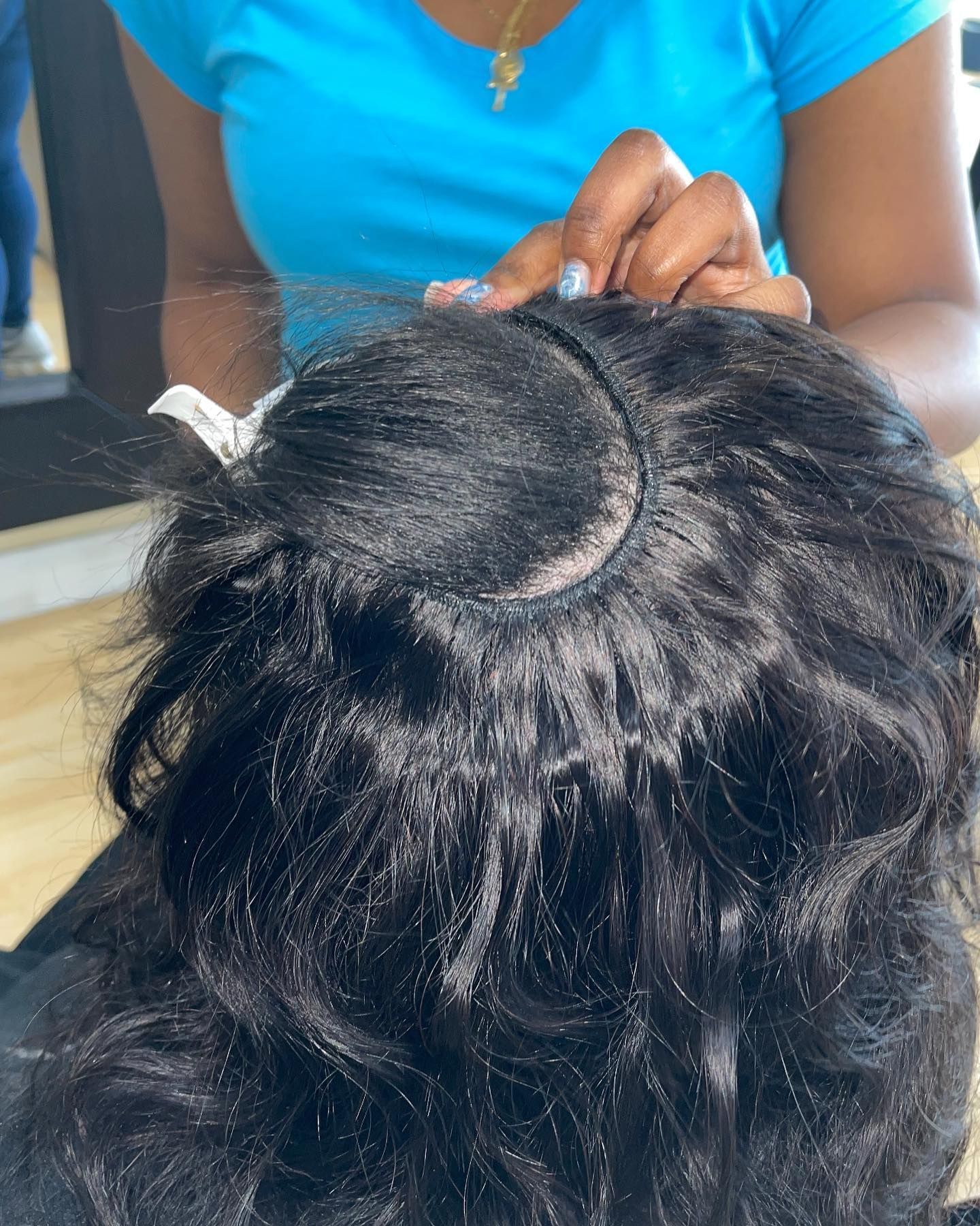 A woman is putting a wig on a woman 's head.