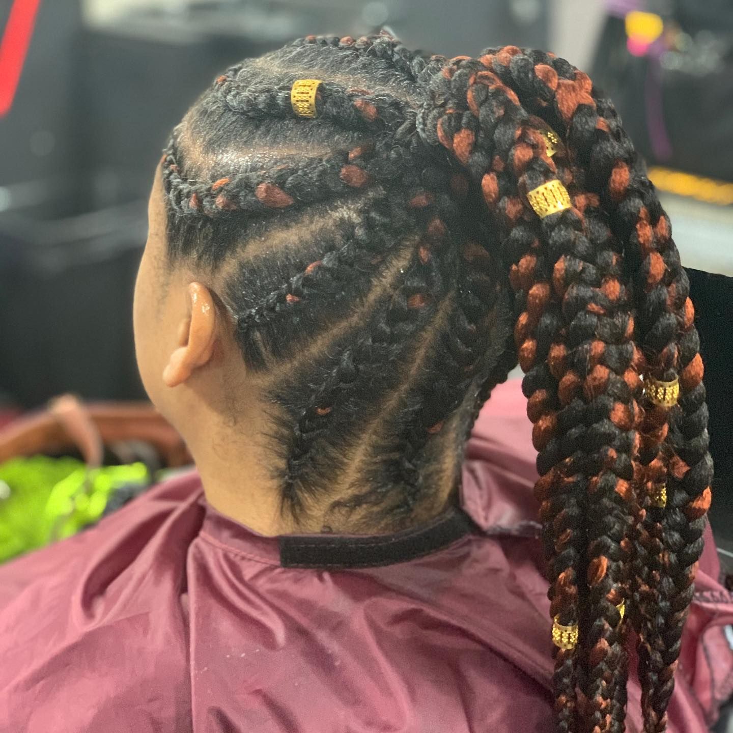 A woman is getting her hair braided in a ponytail