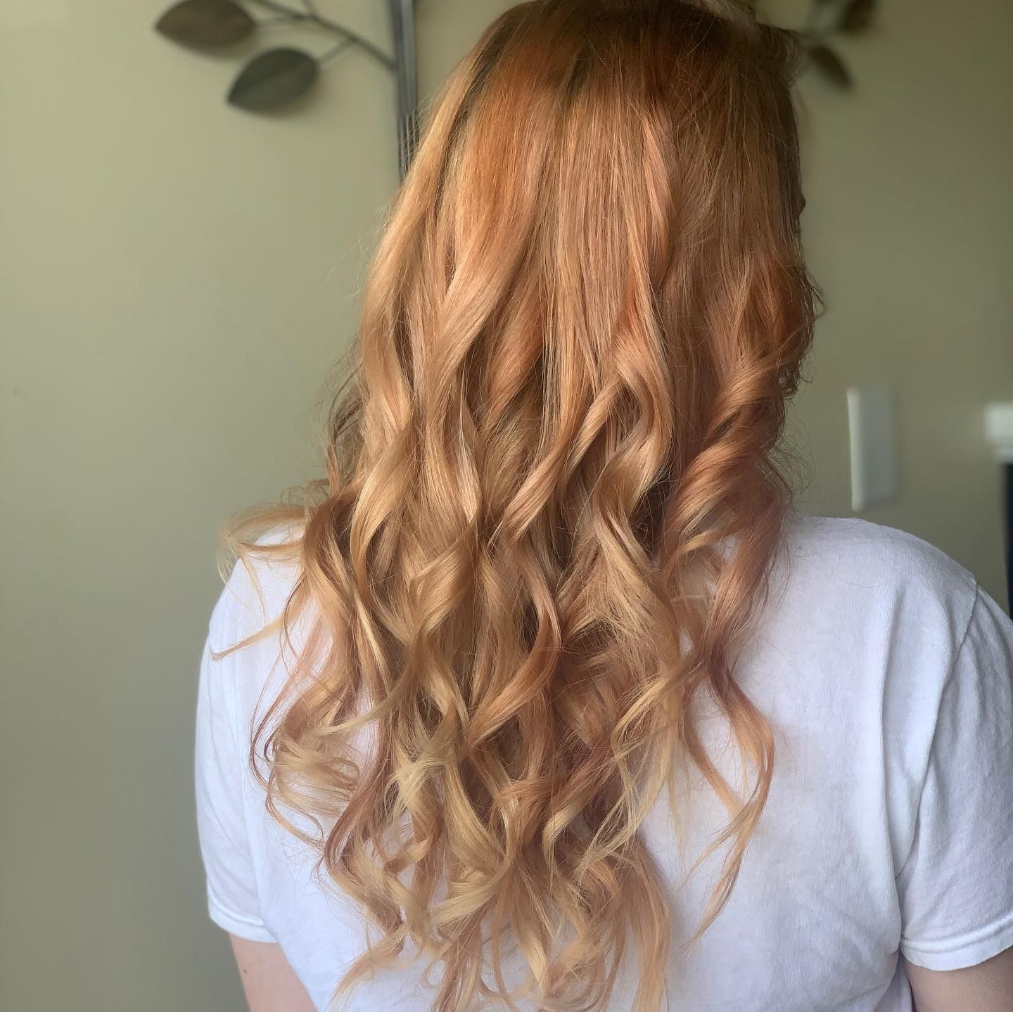 A woman with long red hair is wearing a white shirt.