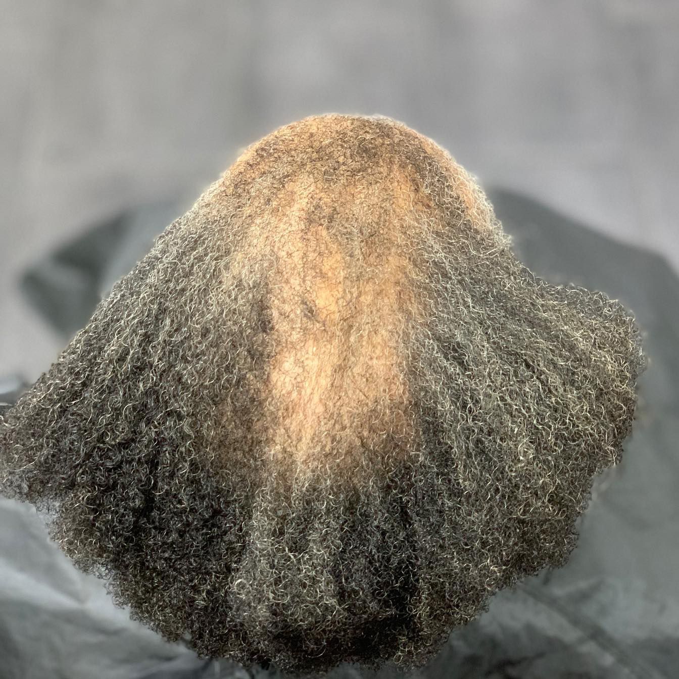 The back of a person 's head with a lot of hair.
