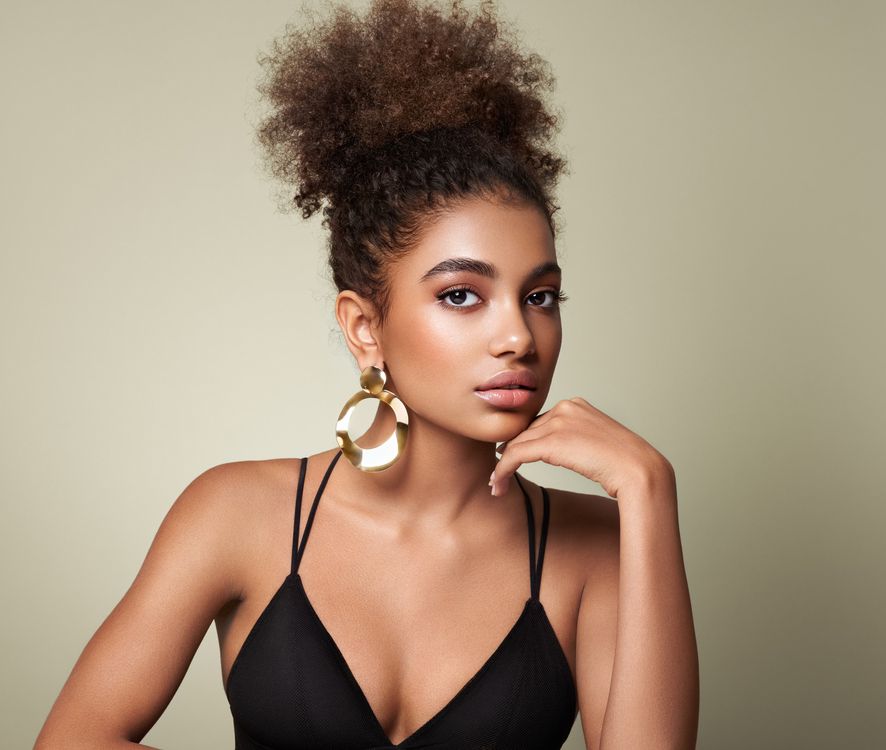 The woman is wearing a black bra and gold earrings.