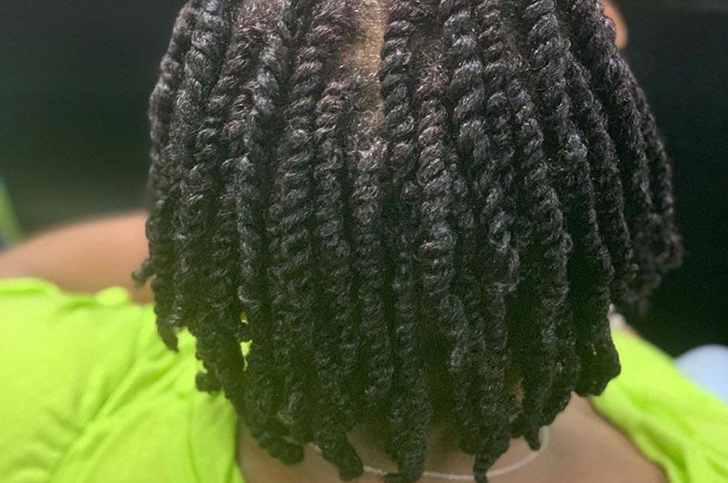 A close up of a person 's hair with dreadlocks.