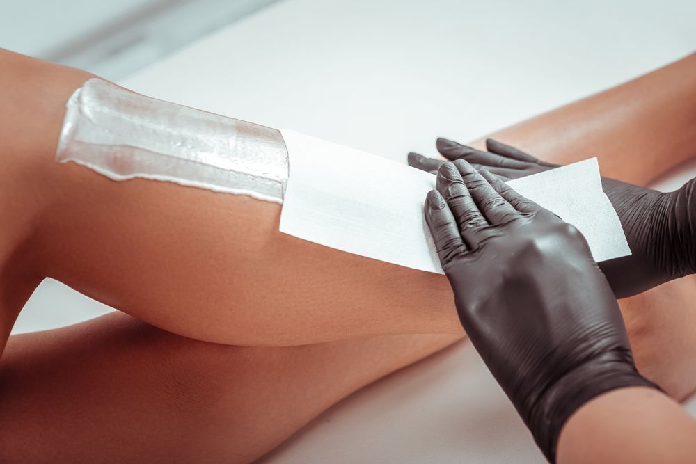 A woman is getting her legs waxed in a beauty salon.