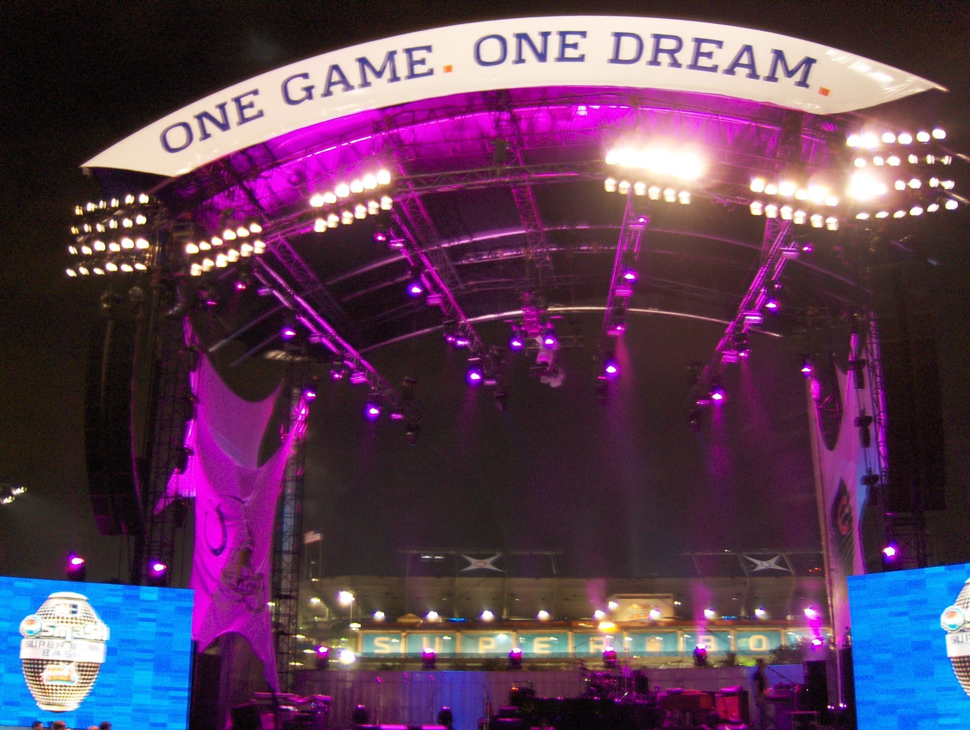 Nighttime stadium stage lit in purple, with arch reading “ONE GAME. ONE DREAM.”