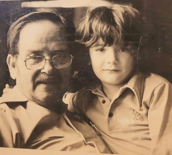 Grandpa and grandson in sepia tone looking directly at camera looking like pals.
