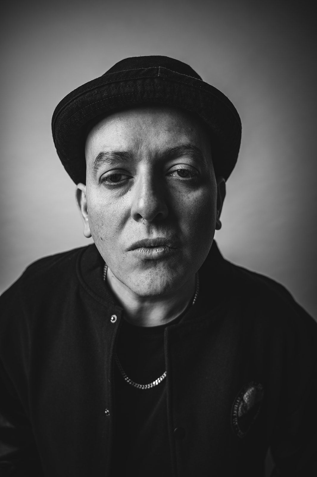 Retrato en blanco y negro de una persona con gorra, mirando al frente con expresión seria.