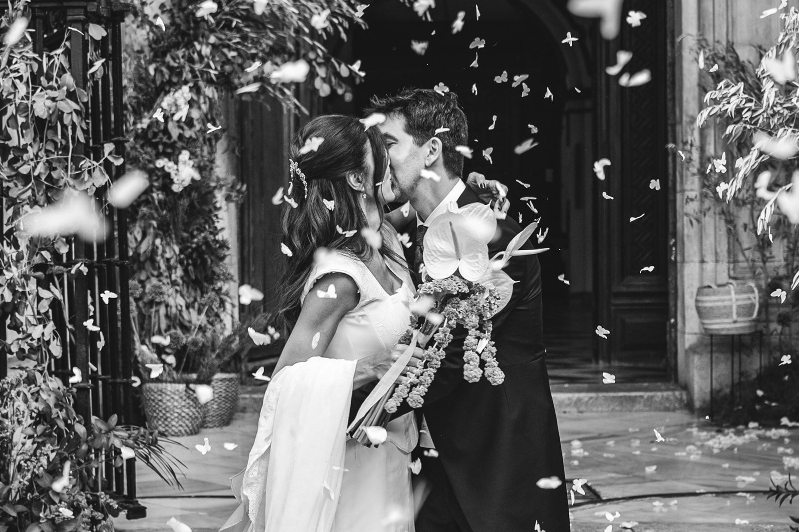 Los novios se besan entre una lluvia de confeti frente a un recinto decorado