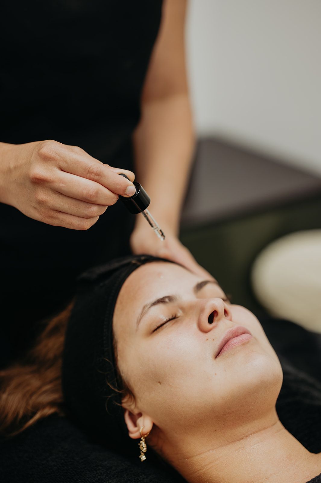 Persona recibiendo un tratamiento facial con sérum aplicado en la frente
