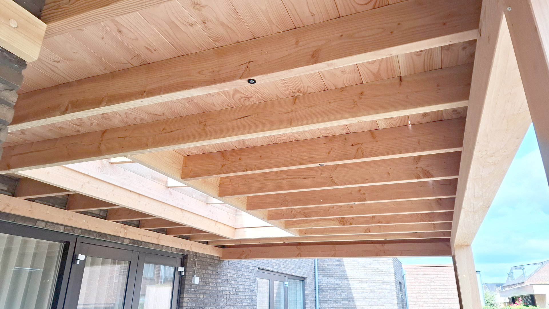 Houten balken die het plafond van een veranda vormen.