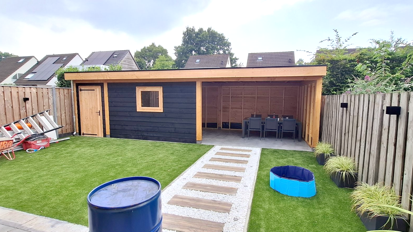 Houten tuinschuur met zwarte en naturel houten delen, en een grindpad.