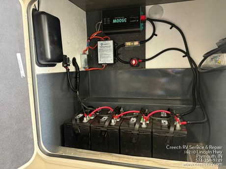 Battery backup system with inverter, wiring, and four batteries in a gray utility box