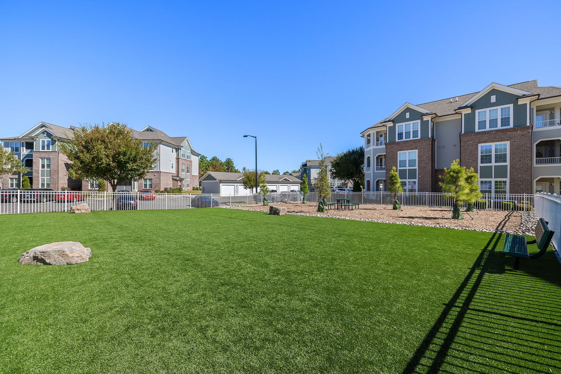 A large off-leash bark park in front of a row of apartment buildings at Marquis Ellis Crossing offers pet-friendly apartments for rent in Durham, NC.