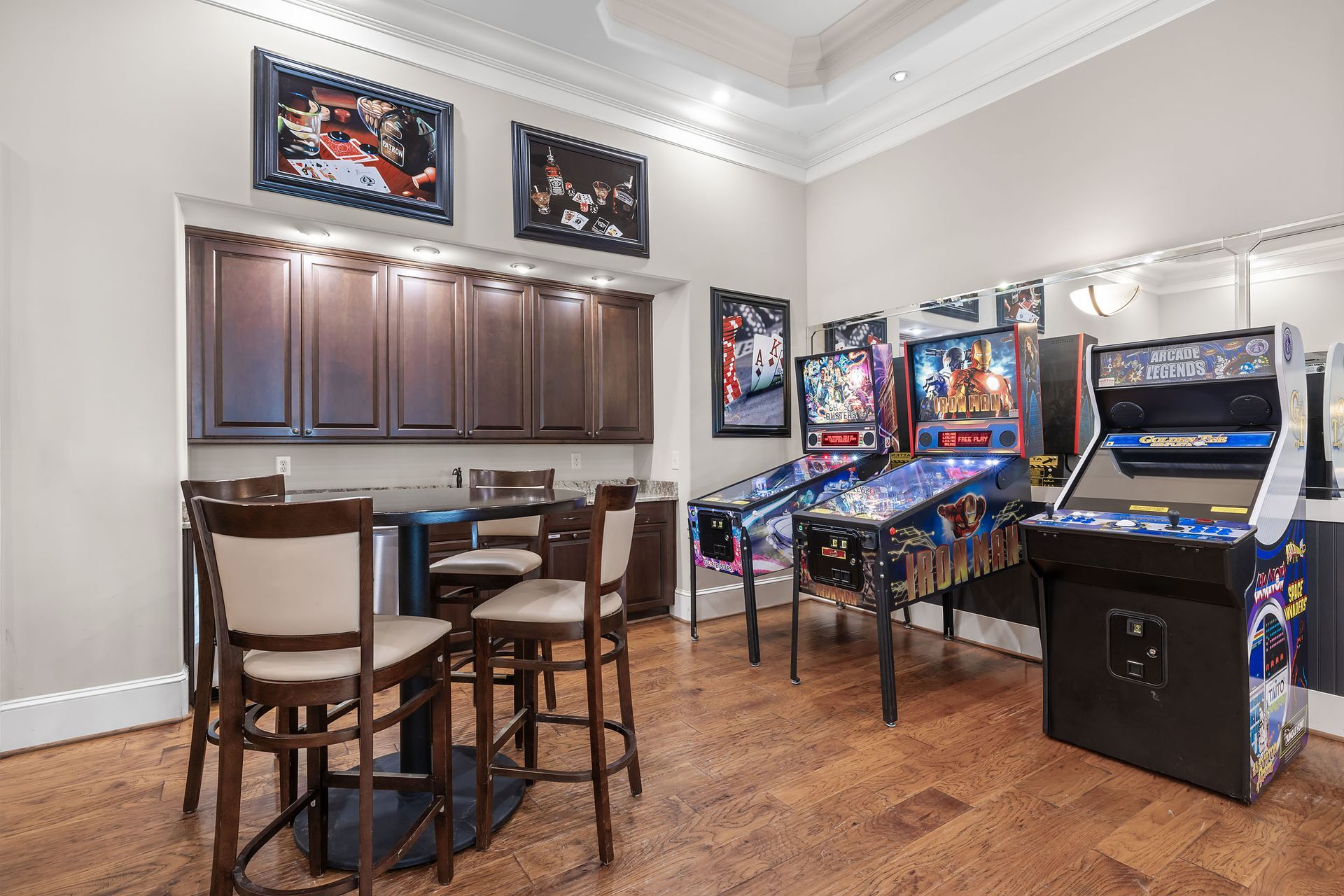 A game room with a table and chairs and a bunch of pinball machines at Marquis Ellis Crossing offers apartments for rent near Duke University, Durham, NC.