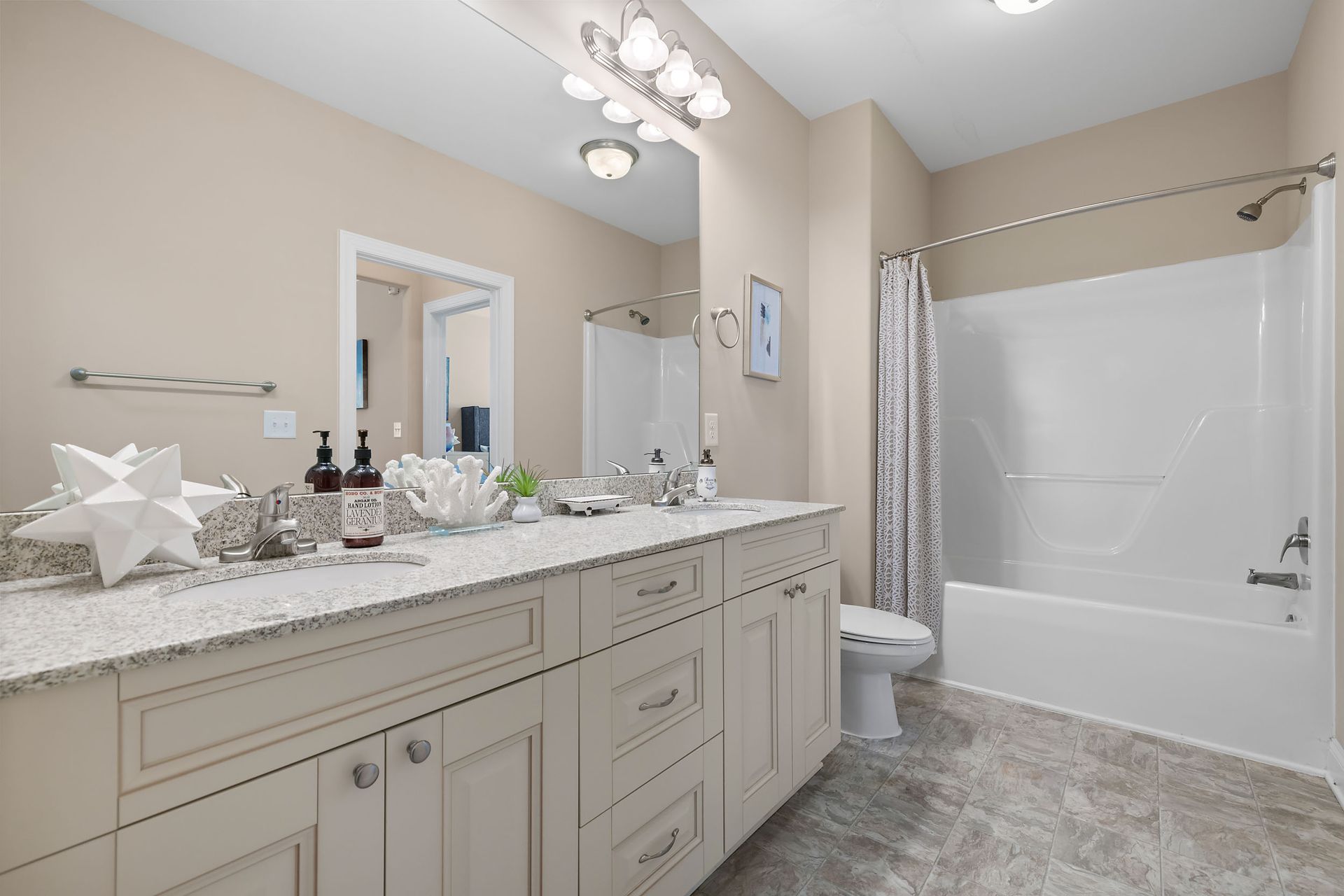 A bathroom with two sinks, a toilet , and a shower at Marquis Ellis Crossing offers apartments near Duke University, Durham, NC.