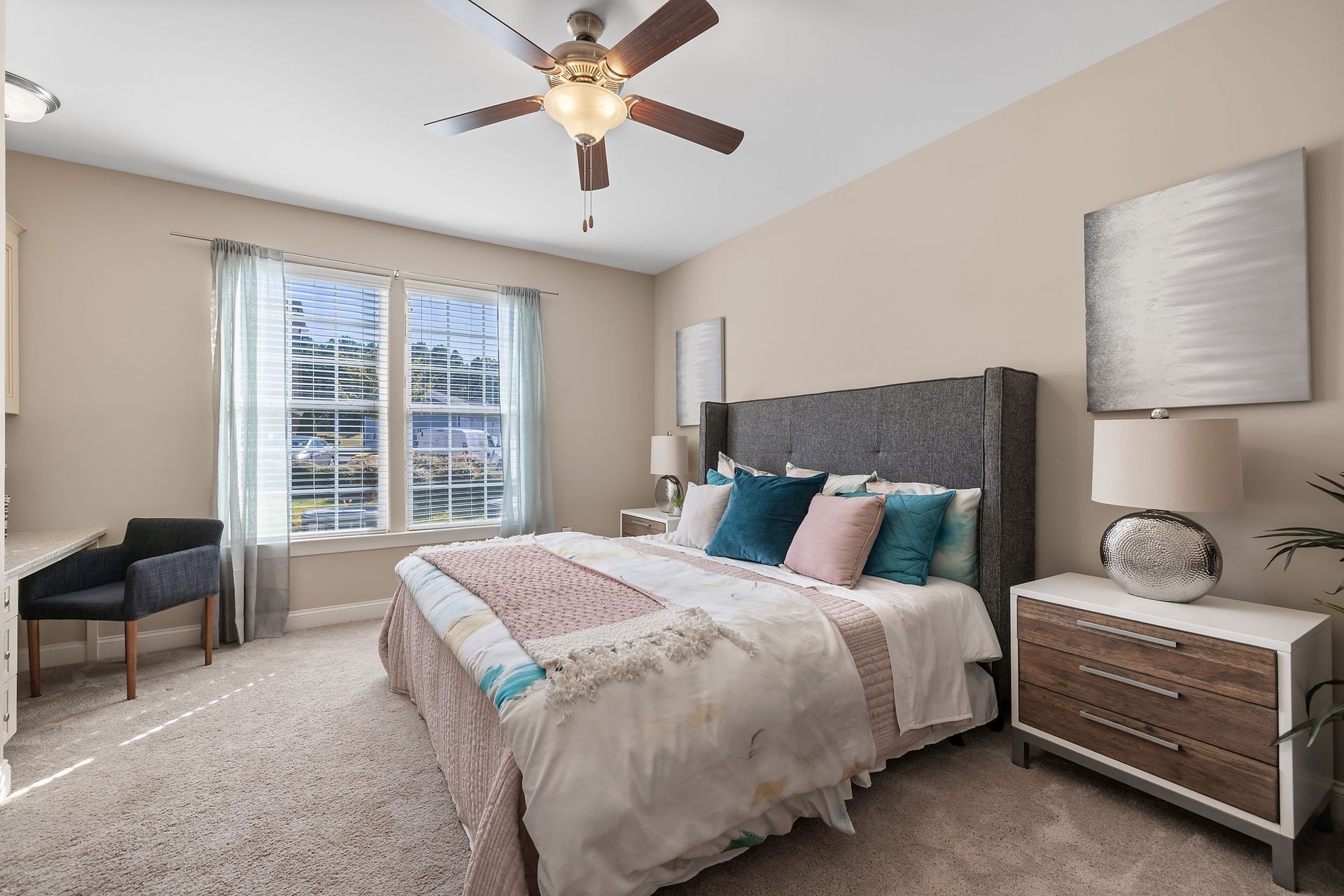 A bedroom with a large bed and a ceiling fan at Marquis Ellis Crossing offers pet-friendly apartments for rent near Duke University, Durham, NC.