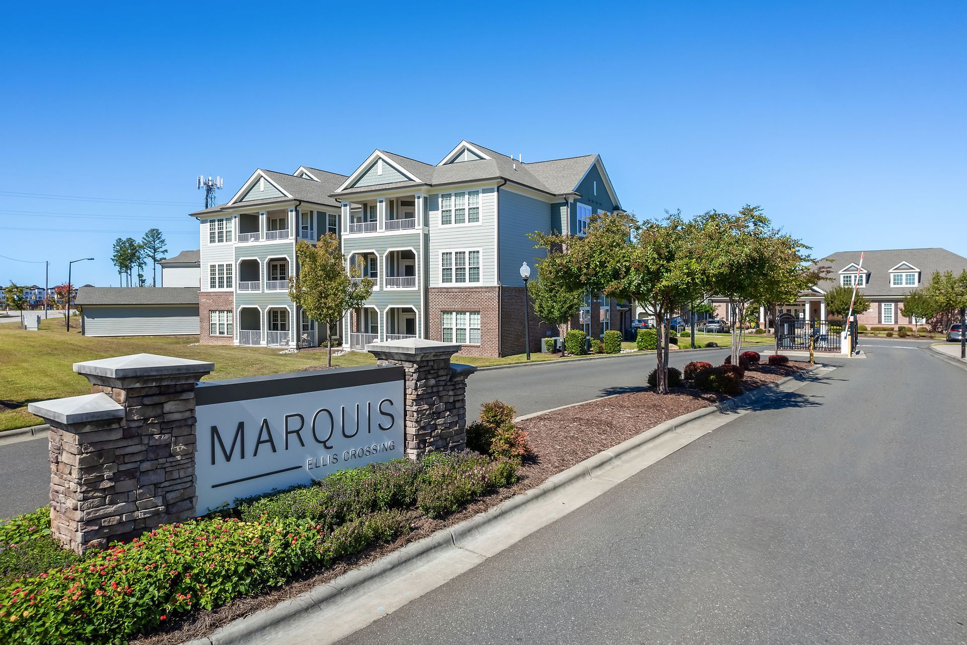 A large apartment building with a sign in front of it that says Marquis Ellis Crossing.