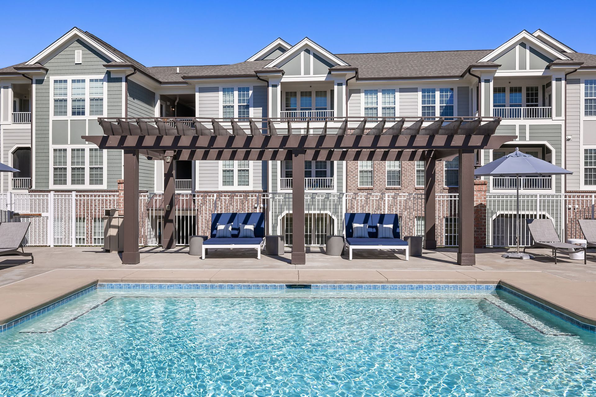 A large apartment building with a swimming pool in front of it at Marquis Ellis Crossing offers pet-friendly apartments in Durham, NC.