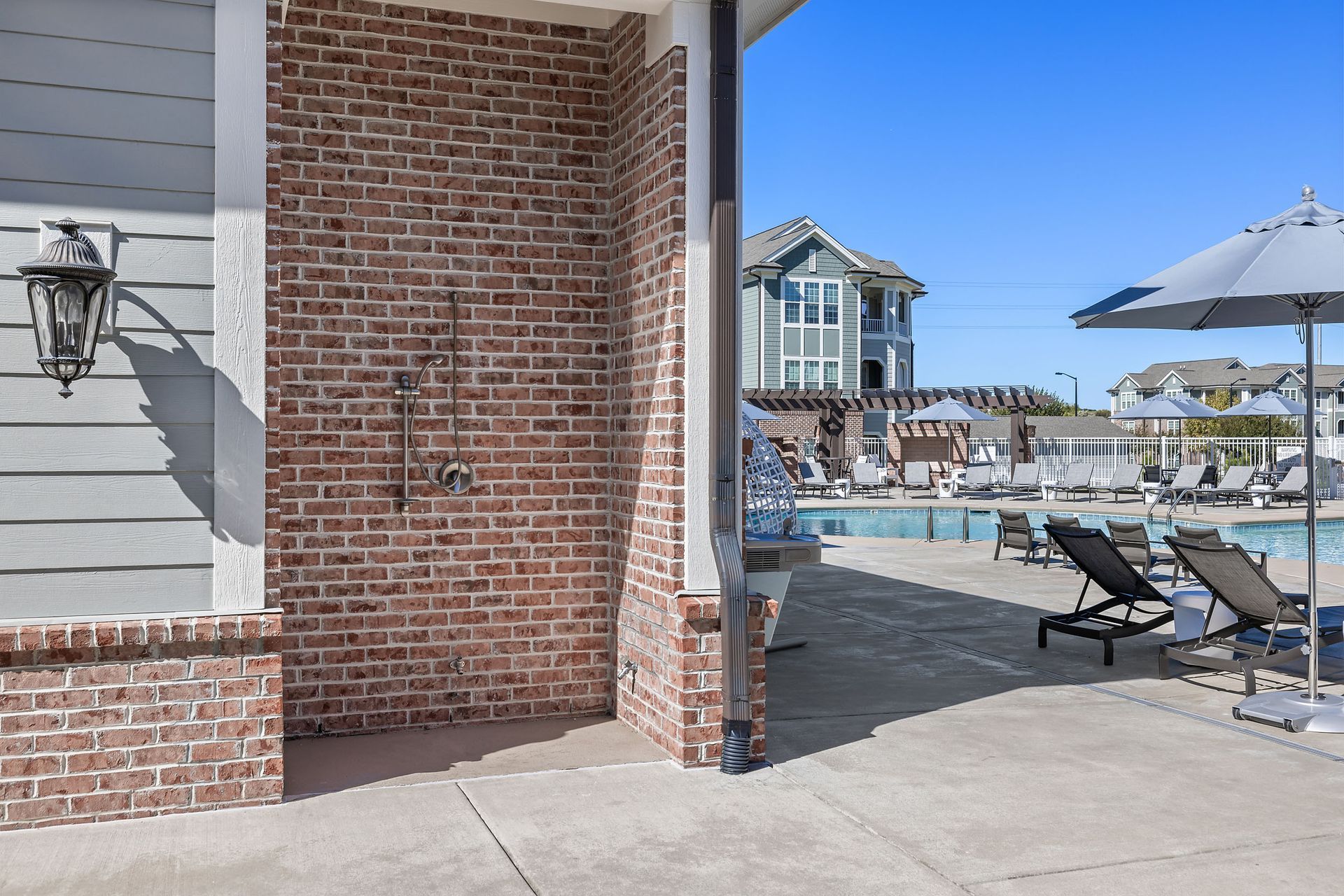 A brick building with a shower next to a pool at Marquis Ellis Crossing offers apartments for rent in Durham, NC.