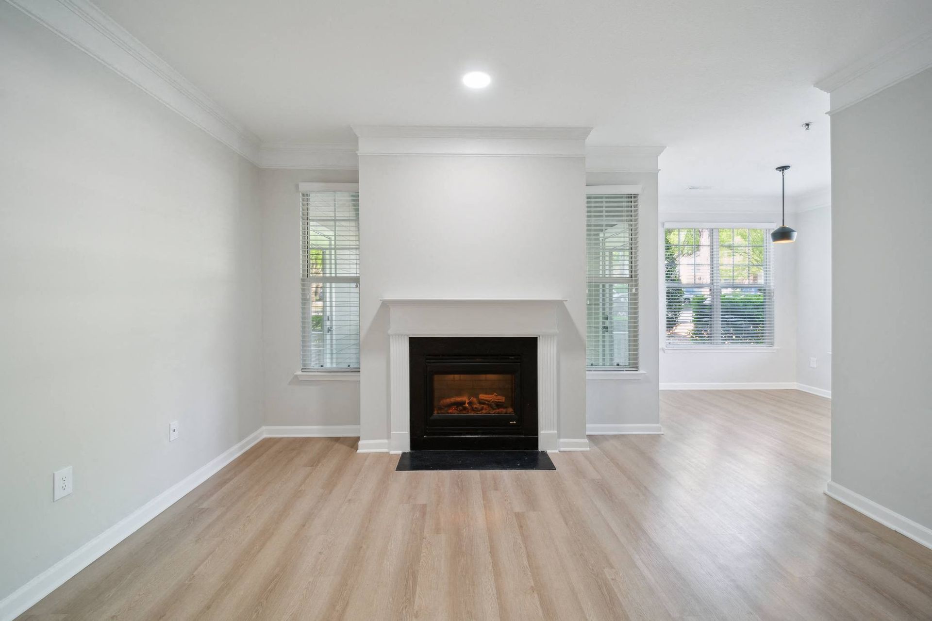 a living room with a fireplace and wooden floors