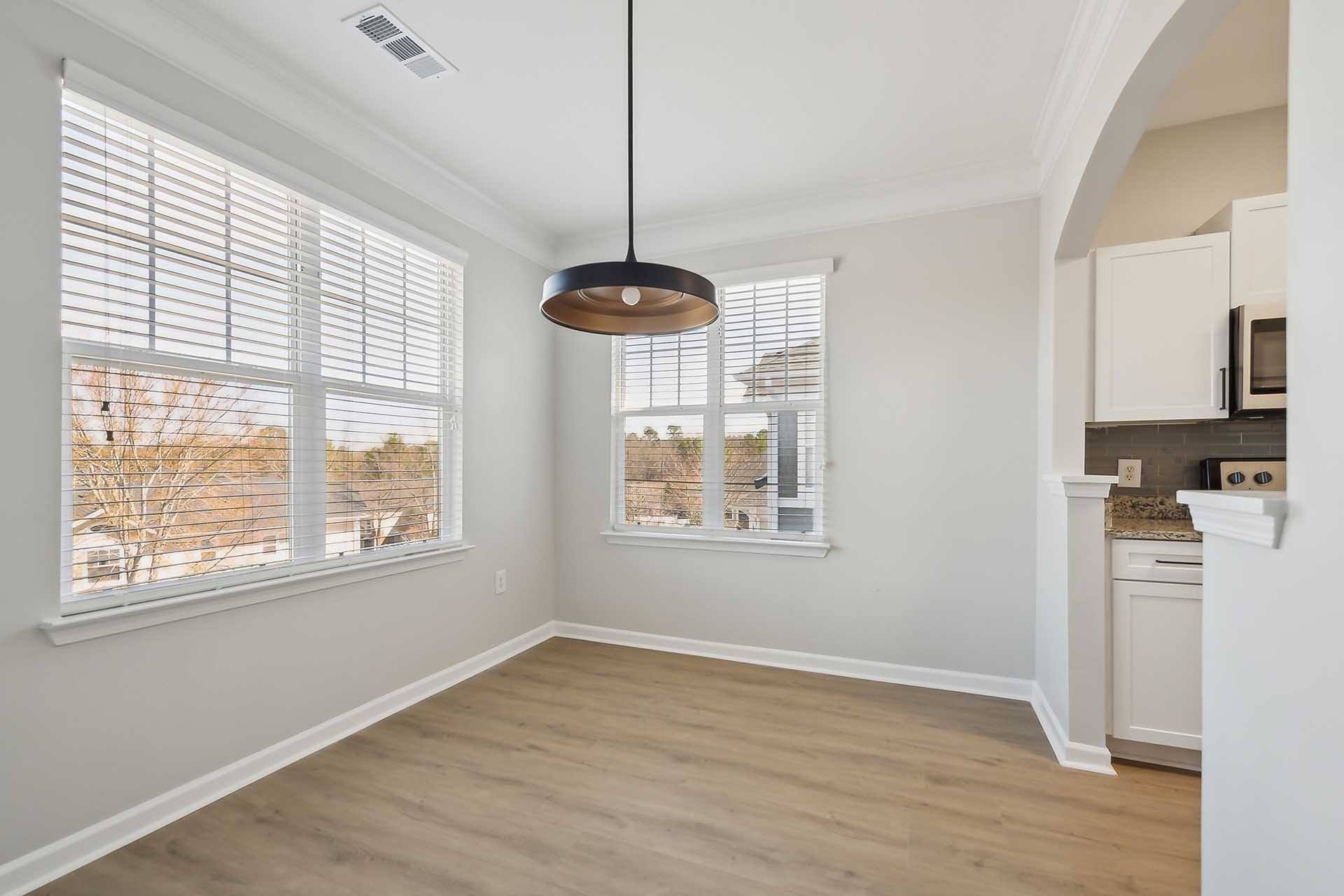 A room with a large window and a hanging light fixture.