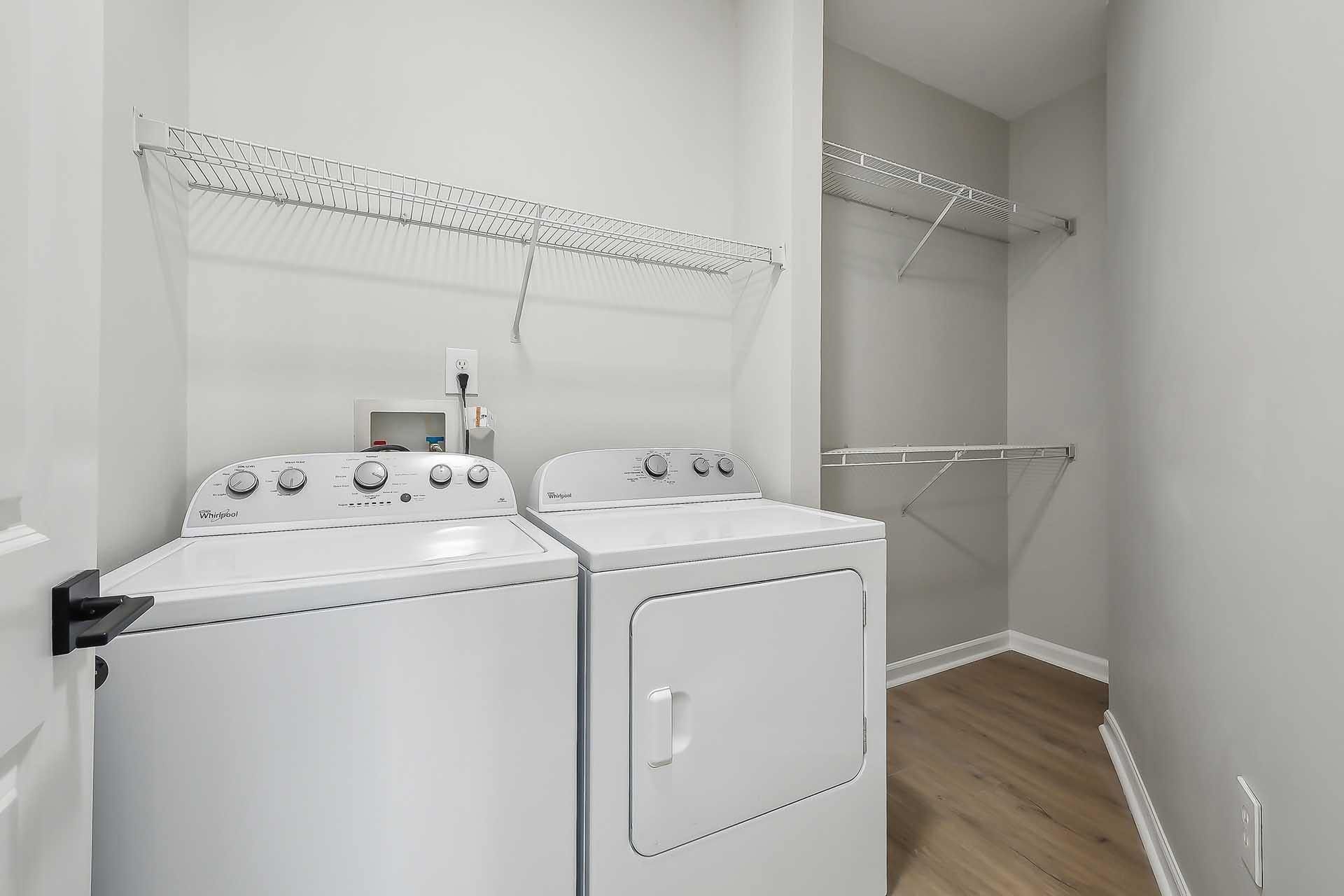 A white washing machine and dryer in a laundry room.