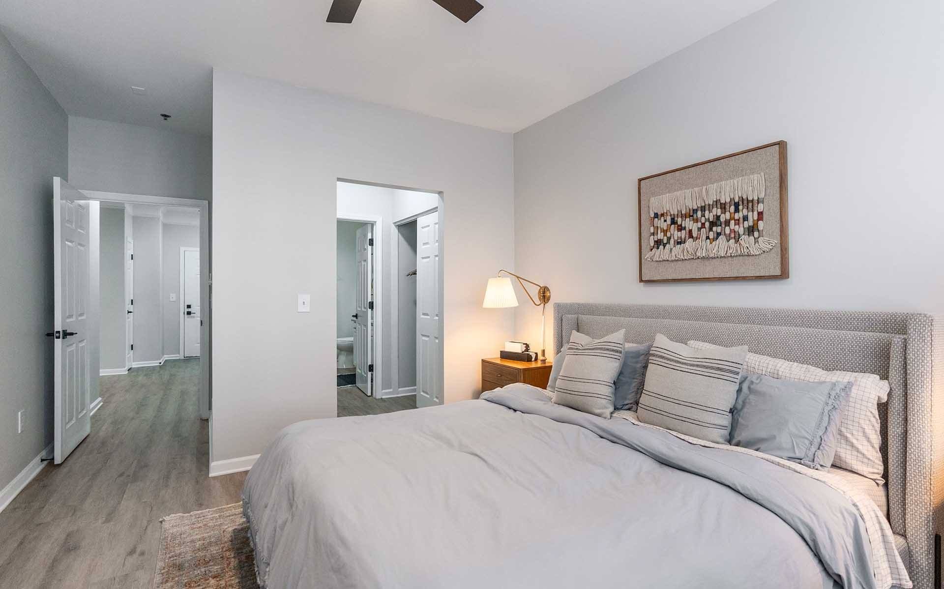 A bedroom with a large bed and a ceiling fan.