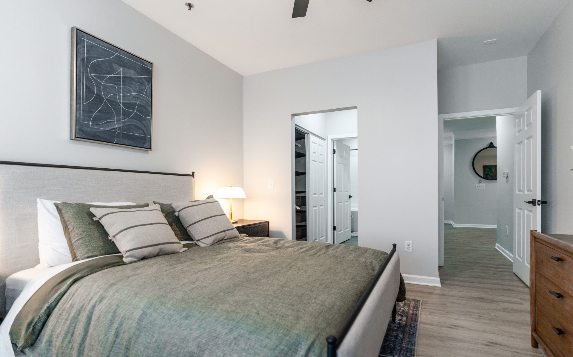 A bedroom with a bed, nightstands, and a painting on the wall.
