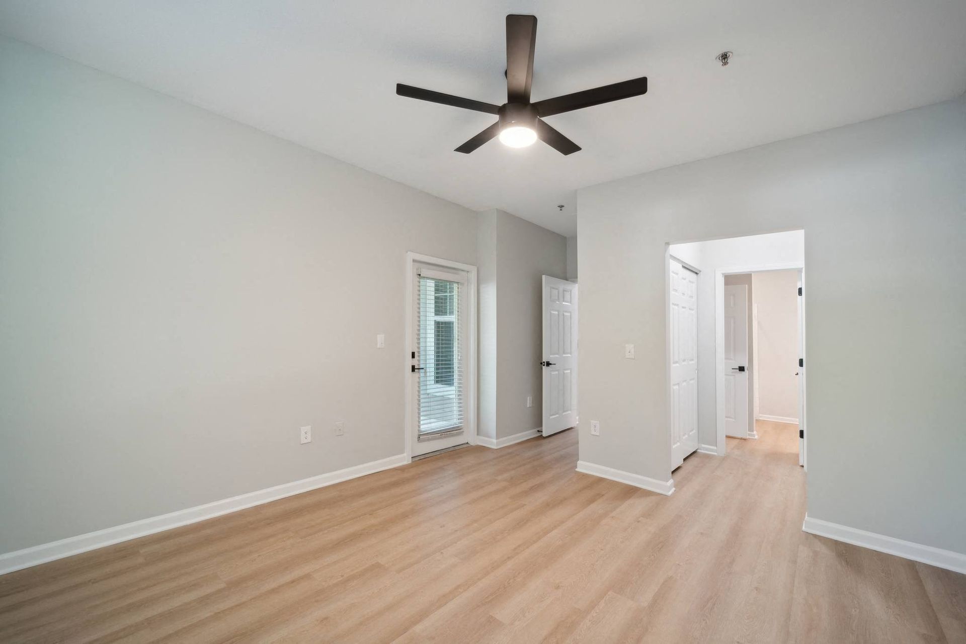 a living room with wood floors and a ceiling fan