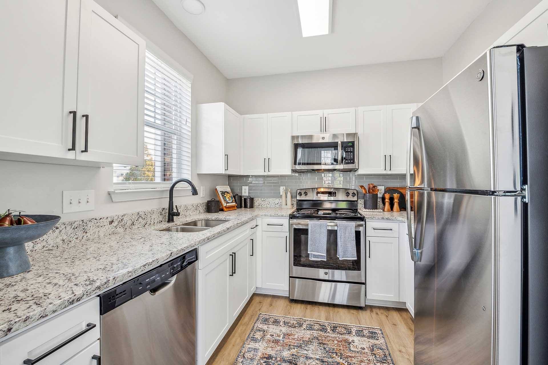 A kitchen with white cabinets and stainless steel appliances.