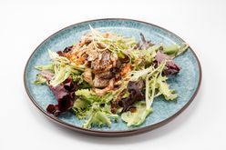 Mixed green salad with grilled chicken on a blue plate