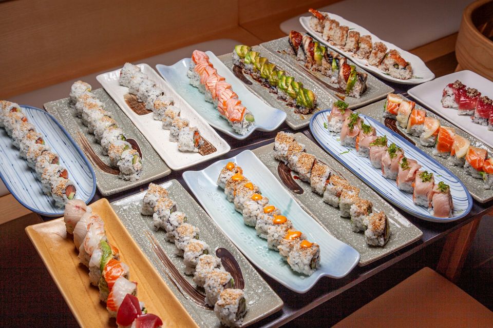 Assorted sushi rolls arranged on platters at a buffet table