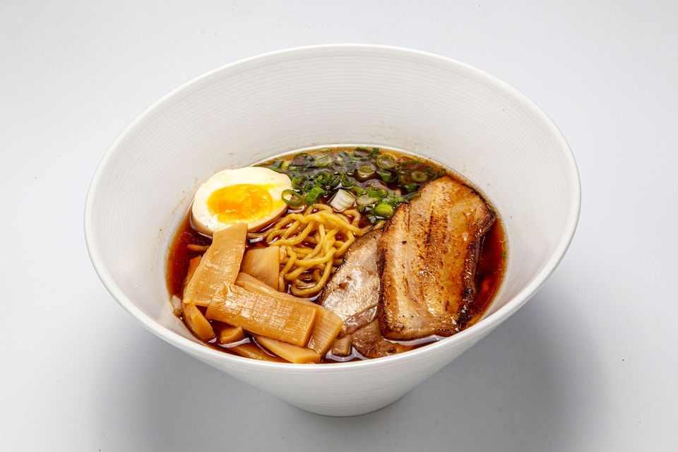 Bowl of ramen with sliced pork, egg, bamboo shoots, and noodles in broth
