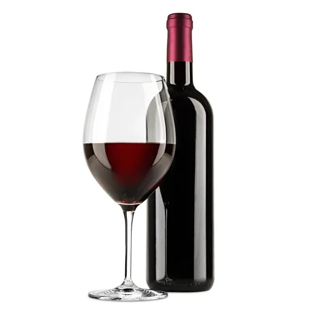 Wine glass filled with red wine beside a dark wine bottle on a white background