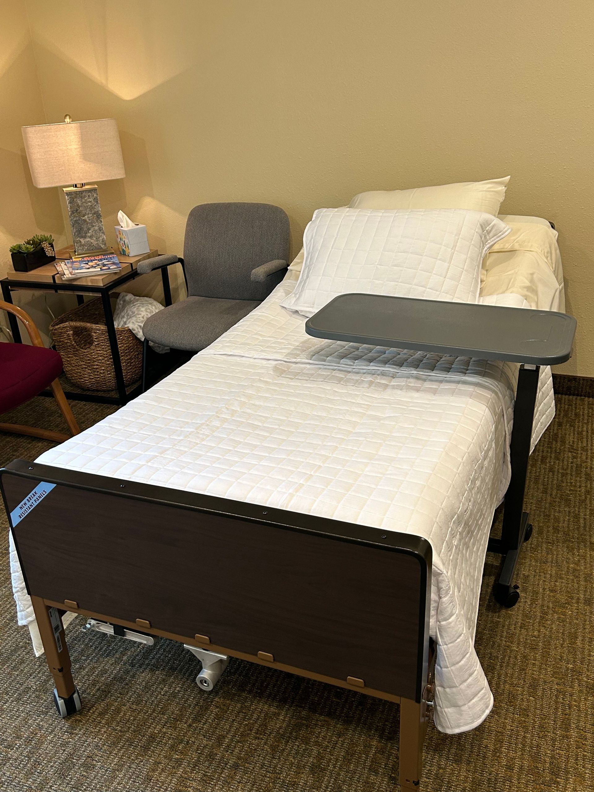 A hospital bed with a table and chairs in a room.