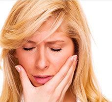 A woman is covering her mouth with her hand.