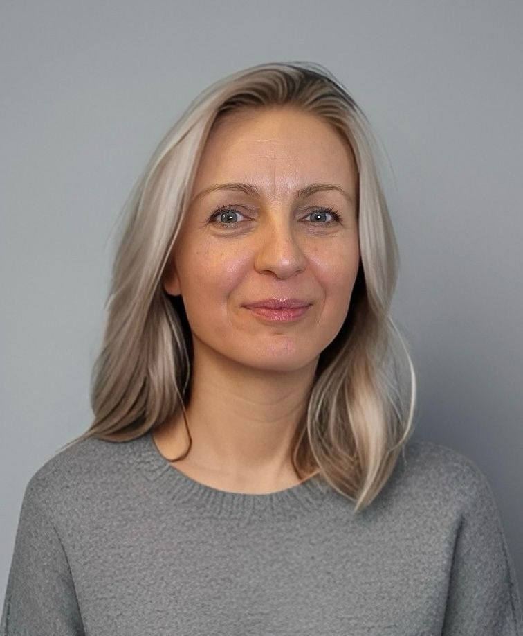 Portrait of a woman in a gray sweater against a plain gray background
