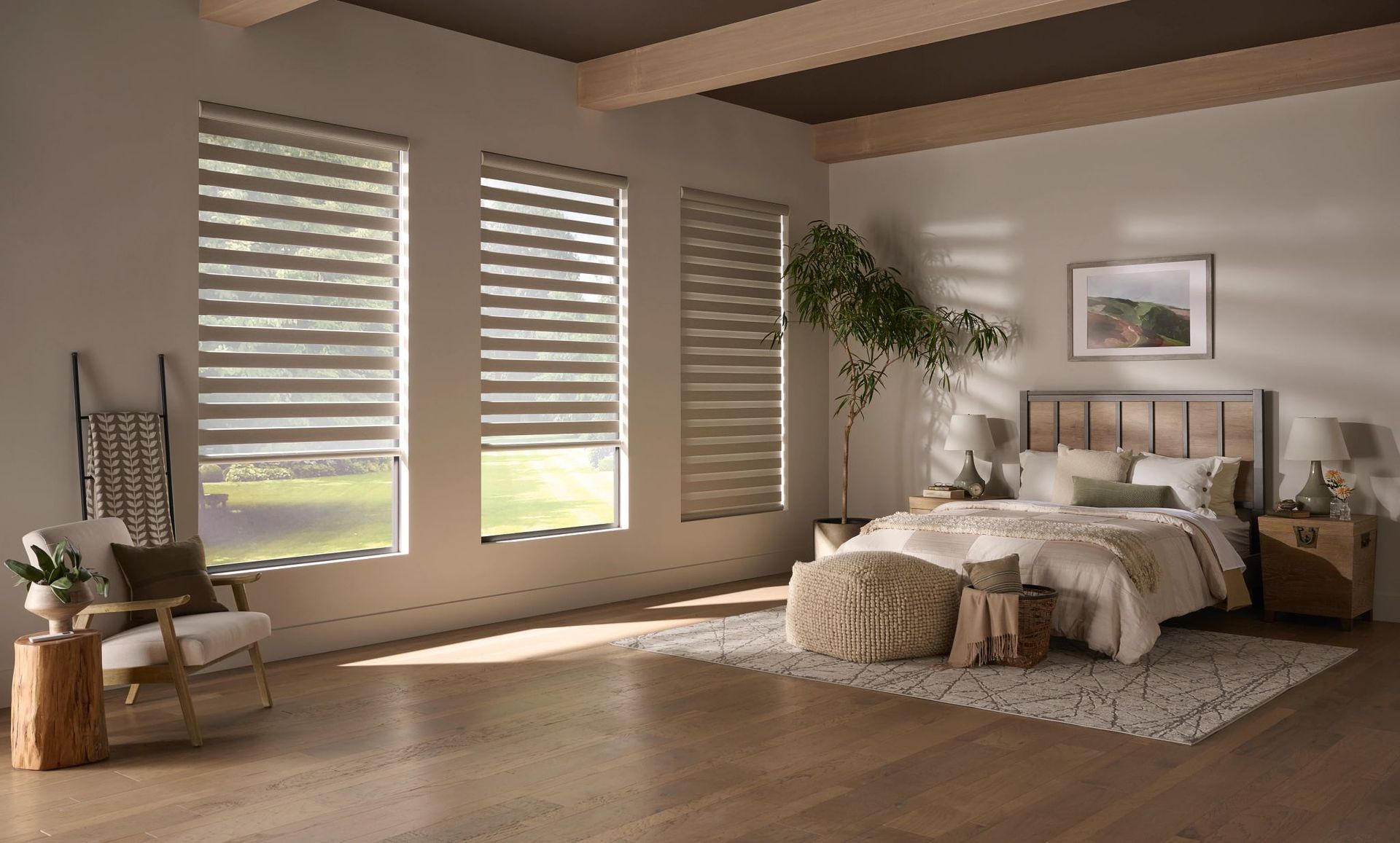 A bedroom with a bed , chair , nightstand and window shades.