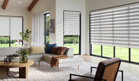 A living room with a couch , chair , table and striped blinds.