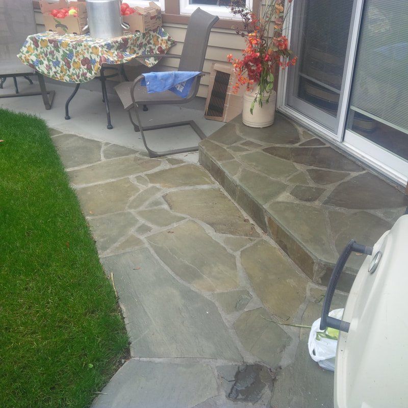 Small flagstone patio and stair step installed in residential backyard of Victoria home