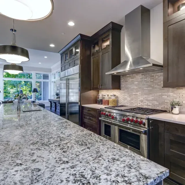 A kitchen with granite counter tops and stainless steel appliances