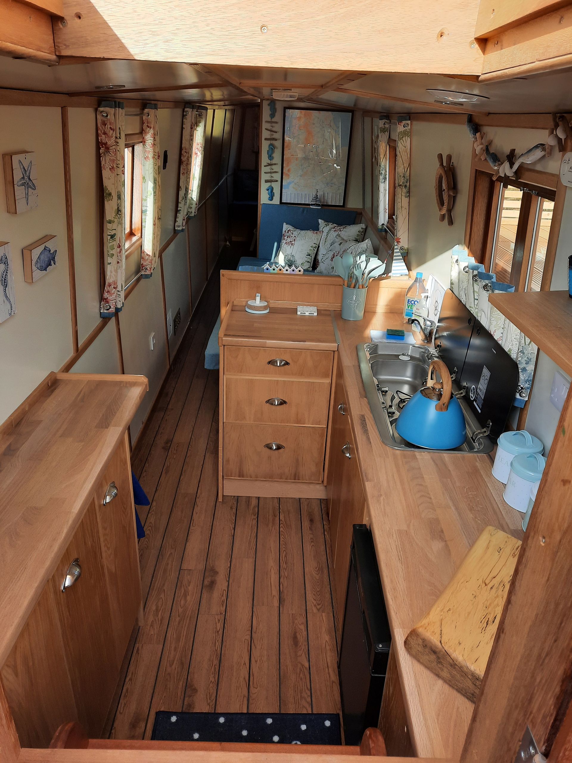A kitchen with wooden cabinets and a blue kettle