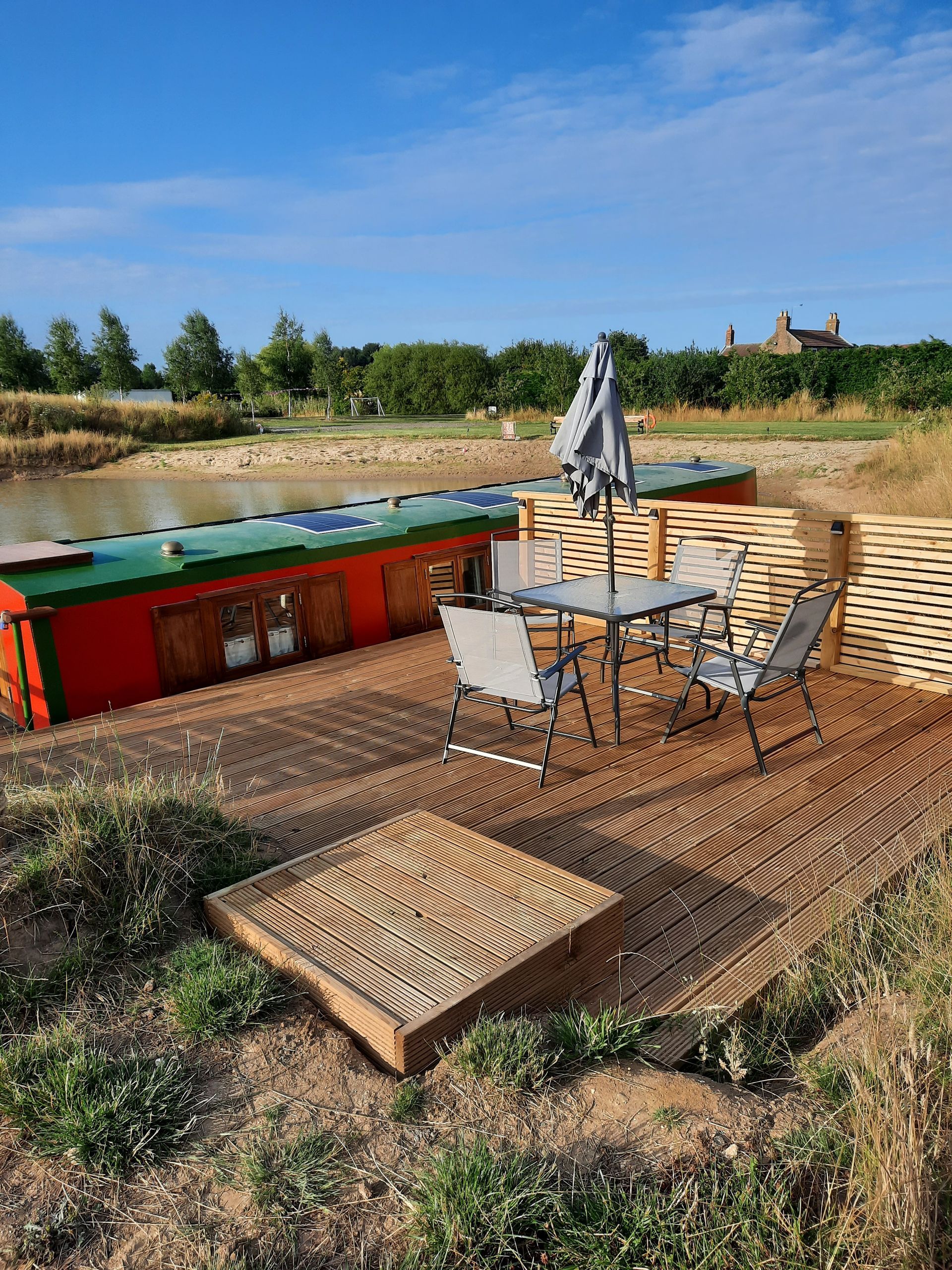 A patio with a table and chairs next to a body of water.
