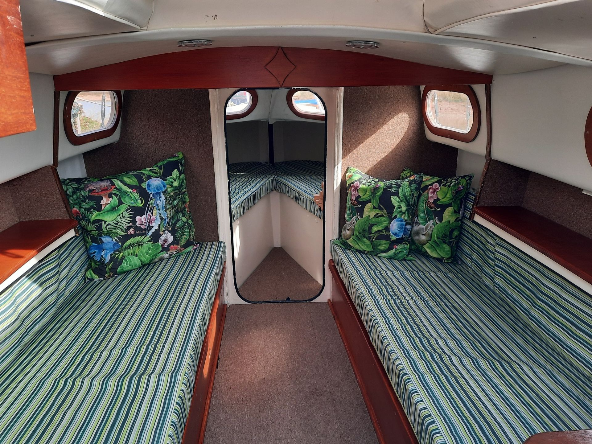The inside of a boat with two beds and pillows