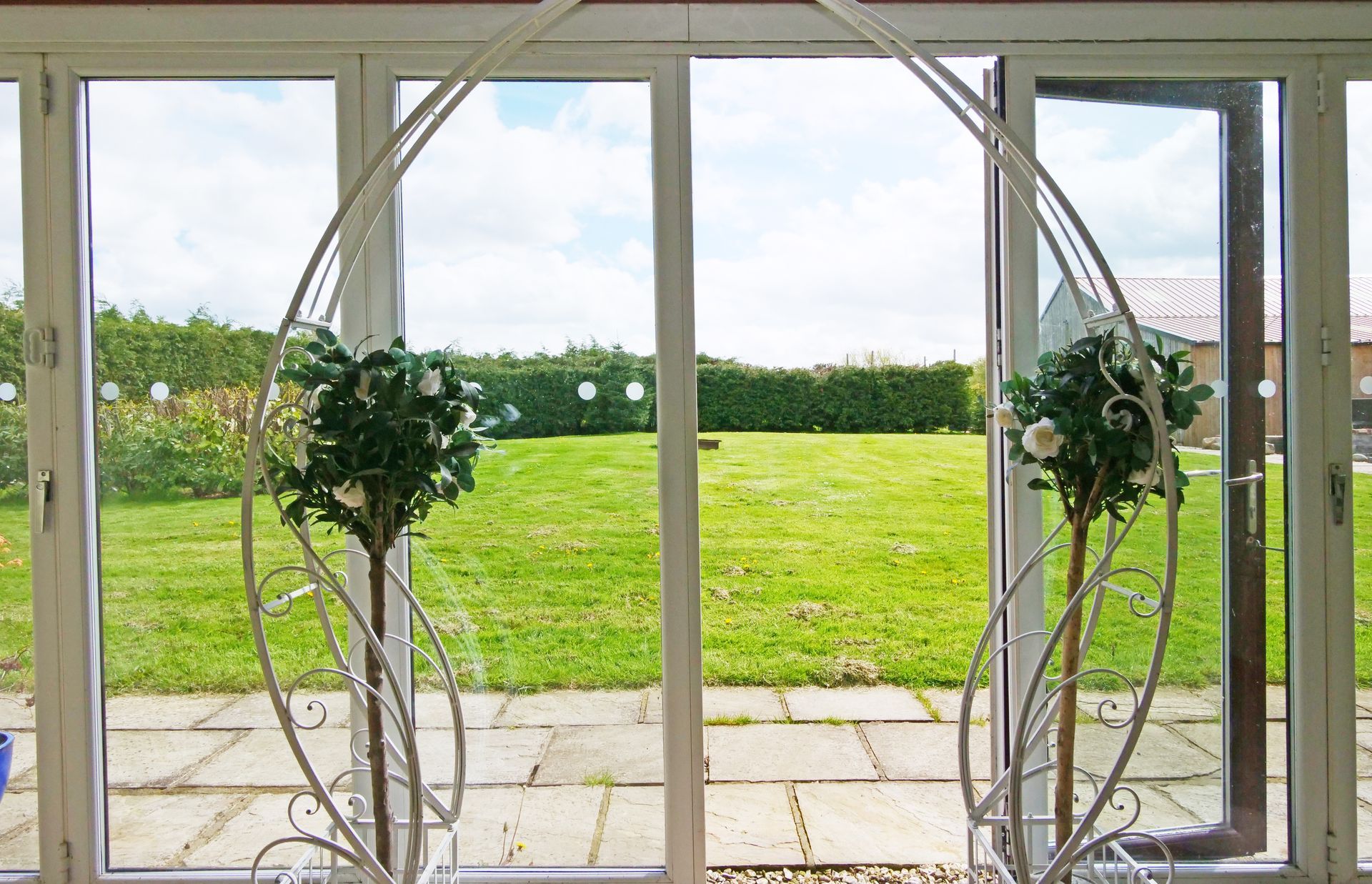 A large window with a view of a lush green field.