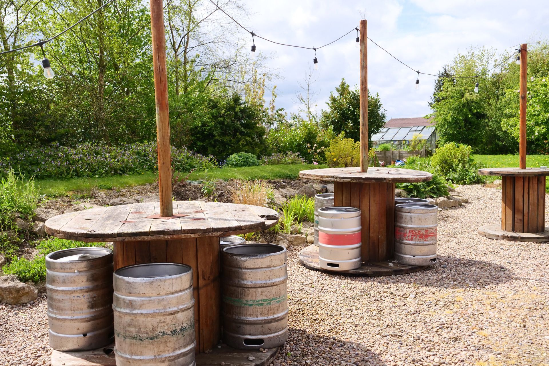 A bunch of kegs are sitting on top of wooden tables.