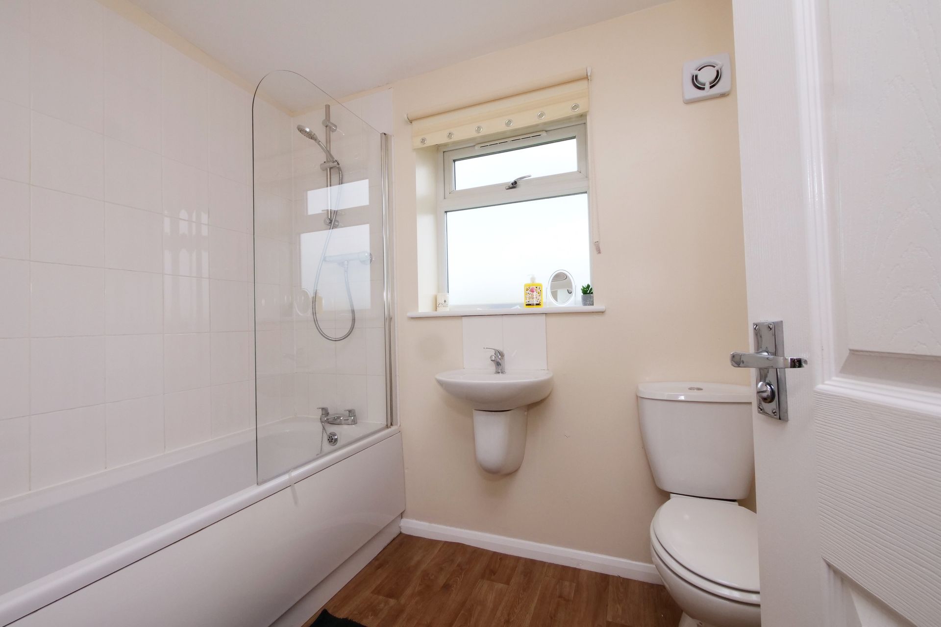 A bathroom with a tub , toilet , sink and window