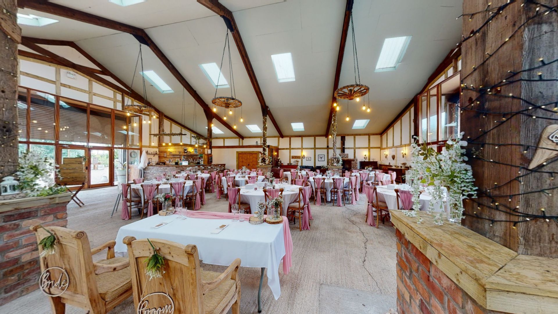 A large room with tables and chairs set up for a wedding reception.