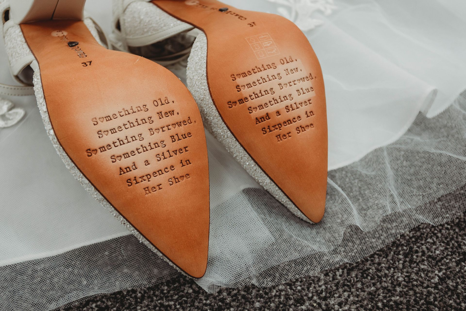 A pair of wedding shoes with a message on the bottom of them